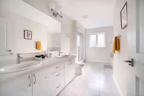 a white bathroom with two sinks and a shower at Severn Woodland in Severn