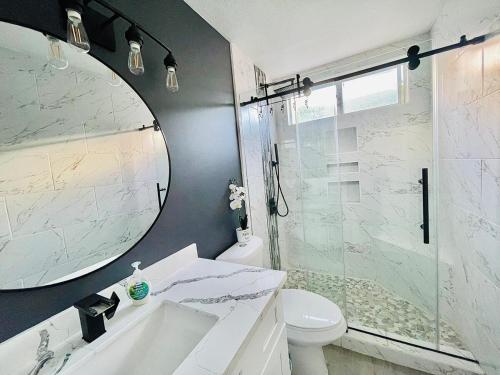 a bathroom with a sink and a toilet and a mirror at Coachella Private Pool Fire Pit BBQ with Chefs Kitchen in Indio