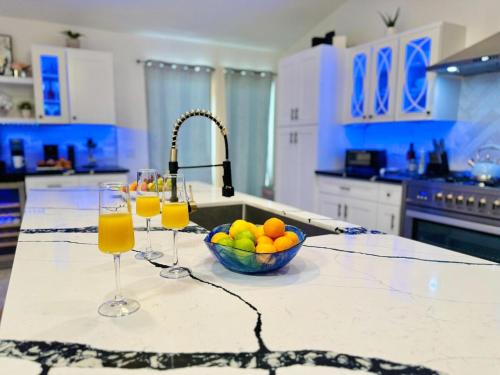 a kitchen counter with a bowl of fruit and two wine glasses at Coachella Private Pool Fire Pit BBQ with Chefs Kitchen in Indio