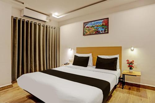 a bedroom with a large bed in a room at Super Townhouse Swain Heritage in Bhubaneshwar