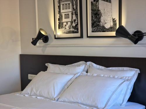 a bed with white pillows and three pictures on the wall at Guest House Marli in Ohrid