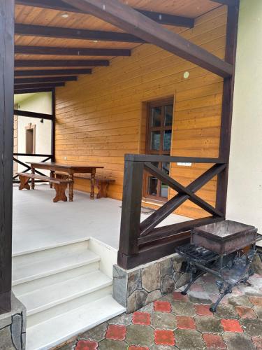 a porch of a log cabin with a picnic table at Вершина in Sheshory