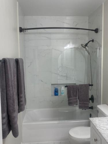 a white bathroom with a tub and a toilet at Cozy Gurnee Home Near Six Flags and Base in Gurnee
