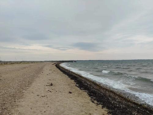 an empty beach with the ocean on a cloudy day at 4 star holiday home in Øster Assels-By Traum in Øster Assels