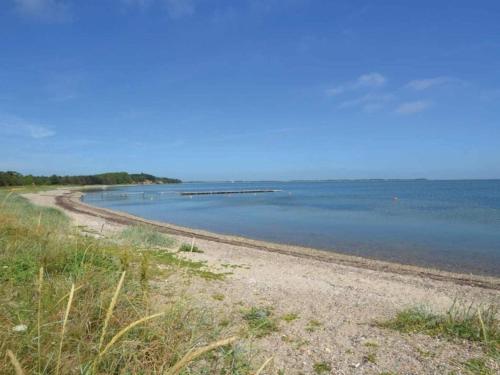 a beach with a dirt road next to the water at 5 person holiday home in Thyholm-By Traum in Thyholm