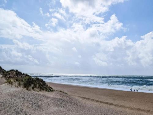 two people walking on a sandy beach near the ocean at 5 star holiday home in Vestervig-By Traum in Vestervig