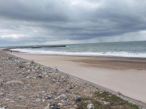 a beach with a person walking on the beach at 5 star holiday home in Vestervig-By Traum in Vestervig