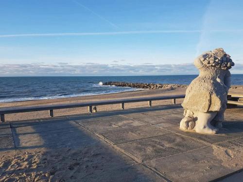 a statue of a dog sitting on the beach at 5 star holiday home in Vestervig-By Traum in Vestervig