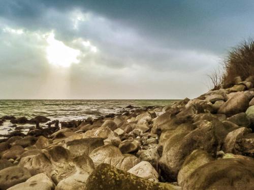 a group of rocks on a beach near the water at Seaside Retreat in Kegnaes - By Traum Ferienwohnungen in Østerby