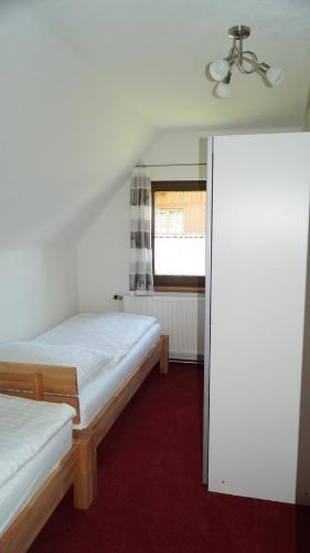 a small room with two beds and a window at Apartment Köll in Aich