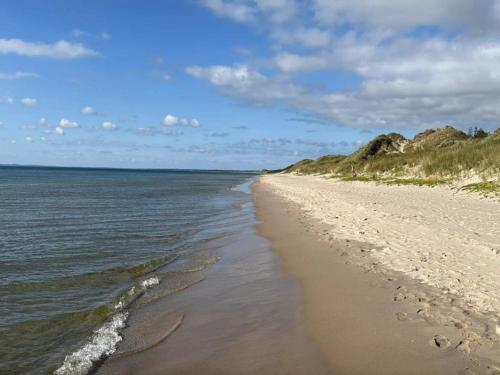 a sandy beach with a view of the ocean at 12 person holiday home in Roslev-By Traum in Roslev