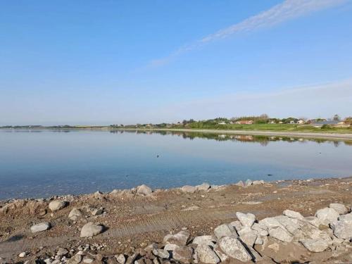 a large body of water with rocks on the shore at 6 person holiday home in Vesløs-By Traum in Øsløs