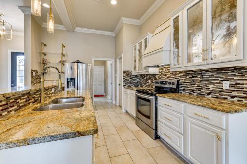 a large kitchen with marble counter tops and white cabinets at Fenced-In Yard and Pond Views Home 18 Mi to LSU! in Riverview