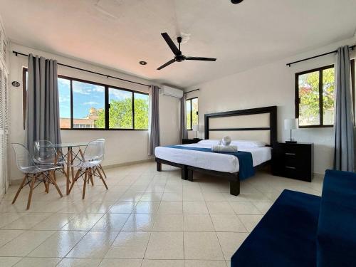 una camera da letto con un letto, un tavolo e delle sedie di Bright Studio with Shared Pool Access a Mérida