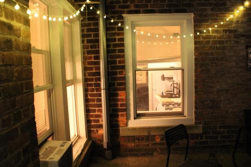 a window with christmas lights on a brick wall at Comfy 1Bed With Full Patio! Free Parking Fast WiFi in Detroit