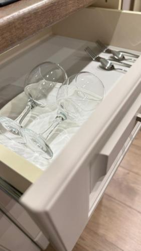 two empty wine glasses sitting on top of a drawer at Апарт-отель NOMERA in Uralsk
