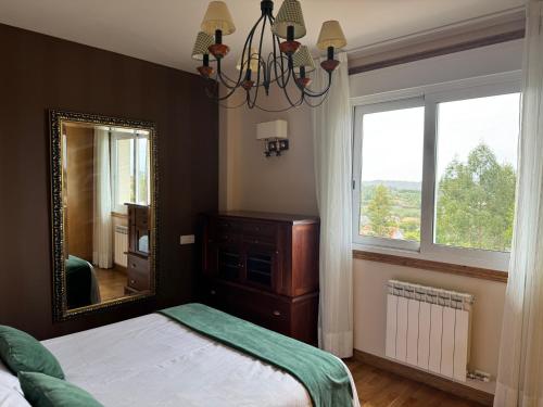 a bedroom with a mirror and a bed and a window at Chalet adosado en Nantes Sanxenxo in Sanxenxo