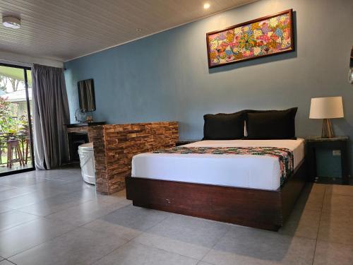 a bedroom with a bed and a painting on the wall at Yellow Tree Suites in Fortuna