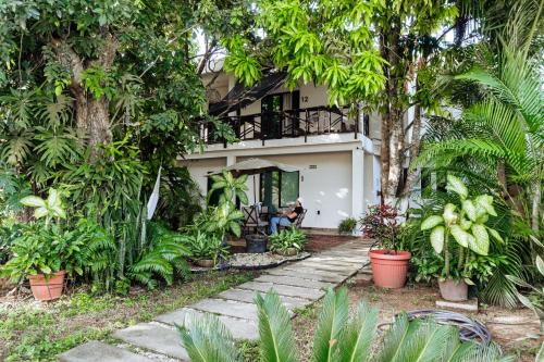 バカラルにあるHotel Brisas Bacalarの木のある家の前に座っている人
