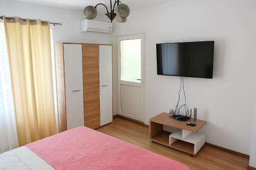a bedroom with a bed and a television on a wall at Apartament Justin in Galaţi