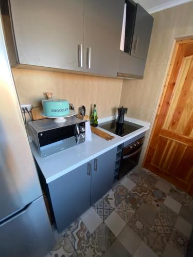 a small kitchen with a microwave and a sink at Casa con piscina in Bahia Inglesa