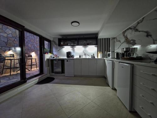 a kitchen with white cabinets and a large window at Guest House Marli in Ohrid