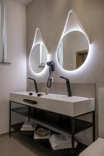 a bathroom with a white sink and two mirrors at Hotel Residenz Luxury - Outletcity - Parken - Klima - 24h Check-In in Metzingen