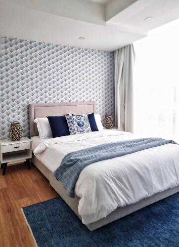 a bedroom with a large bed and a blue rug at Astria Homes- your beach front home in Hulhumale