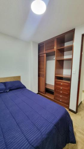 a bedroom with a blue bed and a dresser at Hermosos apartamentos en Funza in Funza