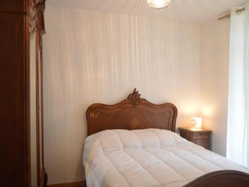 a bedroom with a large bed with a wooden headboard at Maison de plain-pied avec grand jardin clos et parking, à 10 min des vignes. - FR-1-591-223 in Reuilly