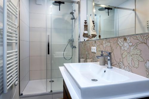 a bathroom with a sink and a shower at FeWo Ostsee Lounge - Meerblick, Sauna, Terrasse in Sassnitz