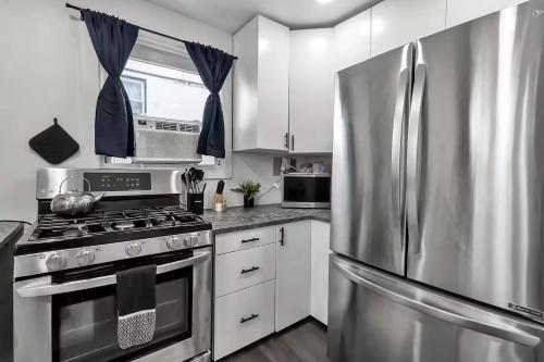 a kitchen with a stainless steel refrigerator and white cabinets at The Victorian House in Buffalo