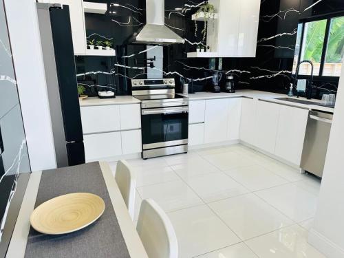 a kitchen with white cabinets and a table with a plate on it at Palm Breeze Getaway in Hollywood