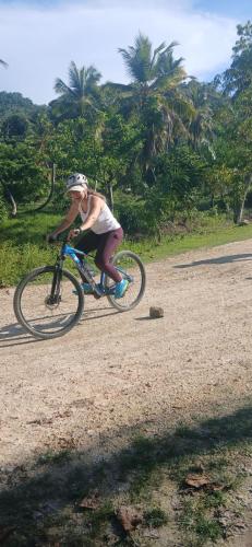 a woman riding a bike on a dirt road at Beach Bungalow 100 m Playa Coson in Las Terrenas
