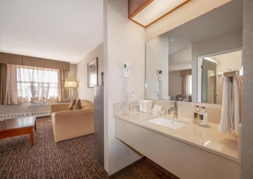 ein Badezimmer mit Waschbecken und großem Spiegel in der Unterkunft Coast Fort St John Hotel in Fort Saint John