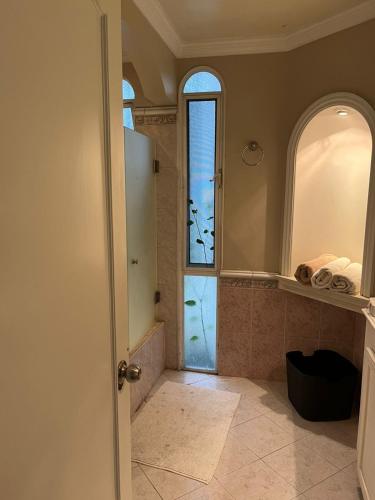 a bathroom with a walk in shower and a glass door at Villa Providencia in Guadalajara