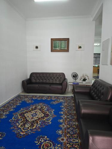 a living room with a couch and a blue rug at NEEK TOMS HOMESTAY MELAKA Near UITM Lendu - MRSM ALOR GAJAH- ENTER EXIT VIA LEBUH AMJ- SELF CHECK-IN in Kampong Alor Gajah