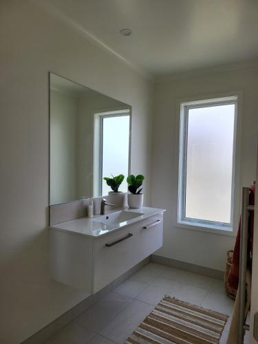une salle de bain blanche avec un lavabo et un miroir dans l'établissement Seacrest, à Ohakana Island