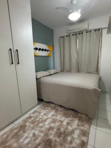 a bedroom with a bed with a window and a rug at Apartamento moderno 15 min da COP30 Wi Fi vaga checkin flexivel COP30 Belém PA Hangar Centro de Convenções in Belém