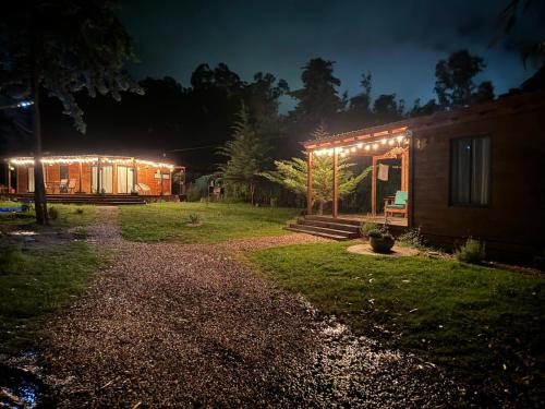 una casa illuminata di notte con luci sopra di Amuleto Cabañas, Bella Vista, Maldonado a Bella Vista