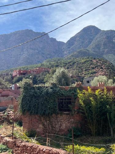 a village with mountains in the background at Ôtel Mrrakchi in Irghaf