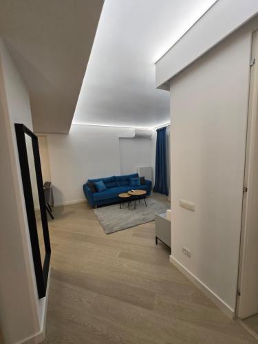 a living room with a blue couch and a table at Luxury Pipera 3Rooms Apartament in Voluntari