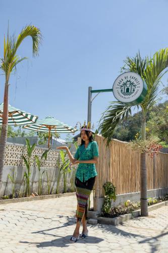 a woman wearing a hat standing next to a fence at Casa de Capulet in Labuan Bajo