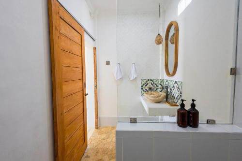 a bathroom with a counter and a wooden door at Casa de Capulet in Labuan Bajo