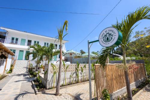 a sign in front of a building with palm trees at Casa de Capulet in Labuan Bajo