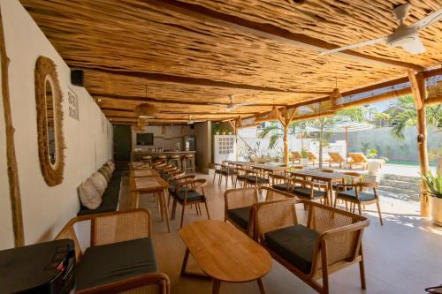 a restaurant with wooden ceilings and tables and chairs at Casa de Capulet in Labuan Bajo