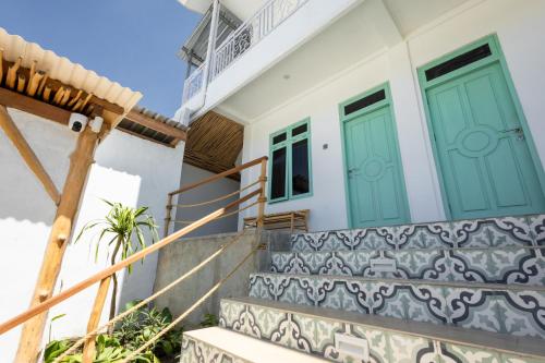 a villa with green doors and stairs at Casa de Capulet in Labuan Bajo