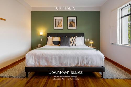 a bedroom with a bed and a green wall at Magis Downtown Juarez by Capitalia in Mexico City