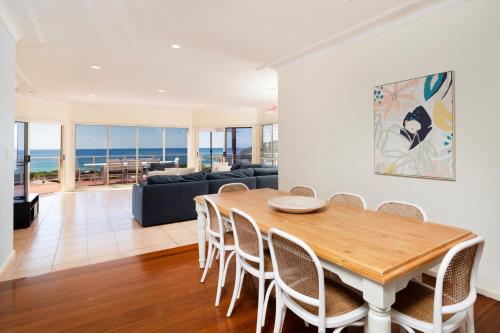 a dining room with a table and chairs at Palm Road in Forster