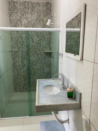 a bathroom with a sink and a shower at Pousada Good Vibes in Japaratinga